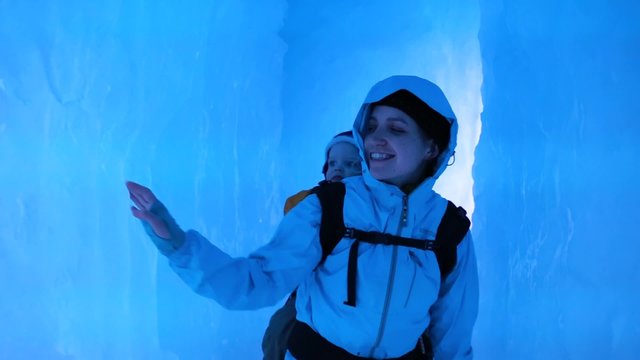 mother and toddler walking in an ice cave