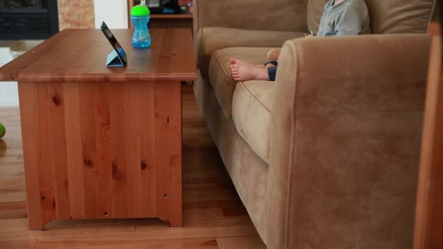 a baby boy watching a show on the ipad