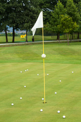 Obraz premium White flag on a golf course, focus on the flag