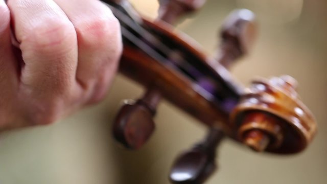 Cowboy playing an old fiddle in cool old barn