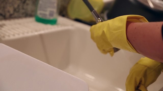 pregnant mother washing dishes at the kitchen sink