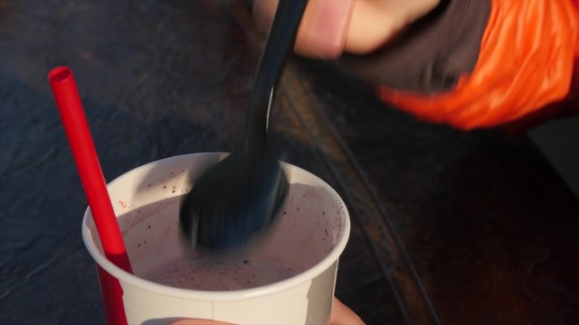 Woman eating a milkshake at a diner
