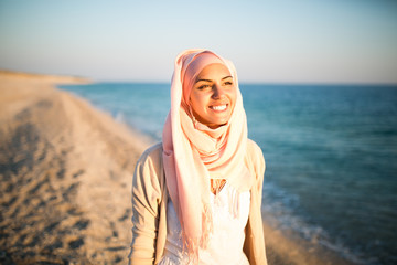 Young beautiful happy muslim woman outdoors portrait.Seaside,beach walk.Beautiful arab saudi woman...