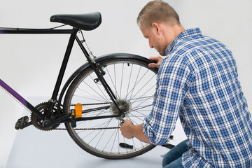 Fototapeta na wymiar Young Man Repairing Bike