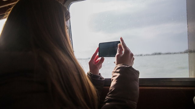 Woman record surrounding while on ship vessel