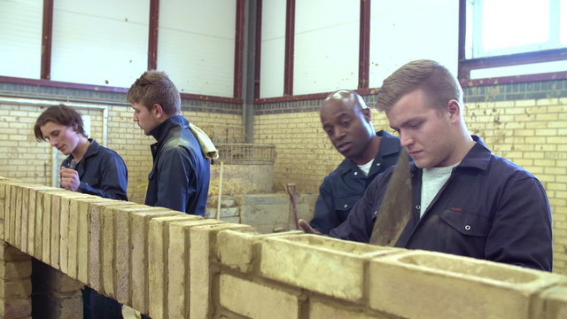 Teacher Helping Students Training To Be Builders