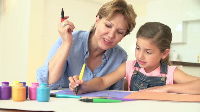 Grandmother Drawing Picture With Granddaughter At Home