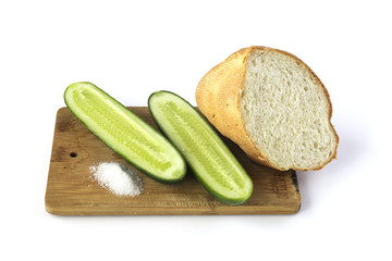 Cut cucumber and bread on a cutting board isolated on white