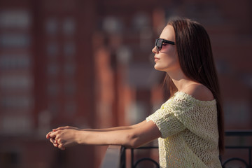 Beautiful girl in sunglasses enjoying the freshness. Sunset summ