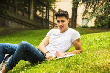 Naklejka na ściany i meble Young Male Student Studying in City Park