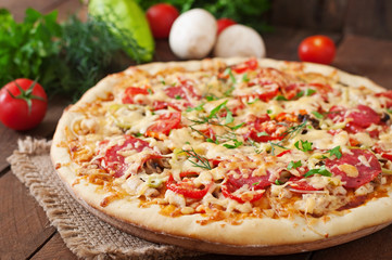 Pizza with salami, tomatoes and mushrooms