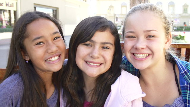 Three Teenage Girls Posing For Camera In Shopping Mall