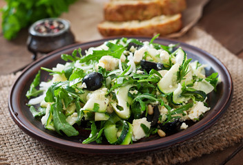 Zucchini salad with feta, olives and pine nuts