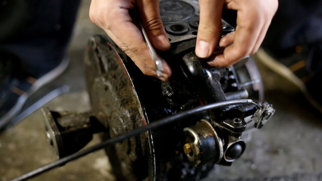 Young man repairing small motor engine