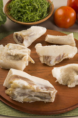 Raw pig tails on wooden background