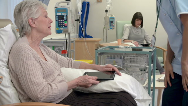Nurse Checking On Senior Female Patient Having Chemotherapy 
