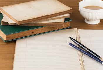 old notebook with pen on wood table