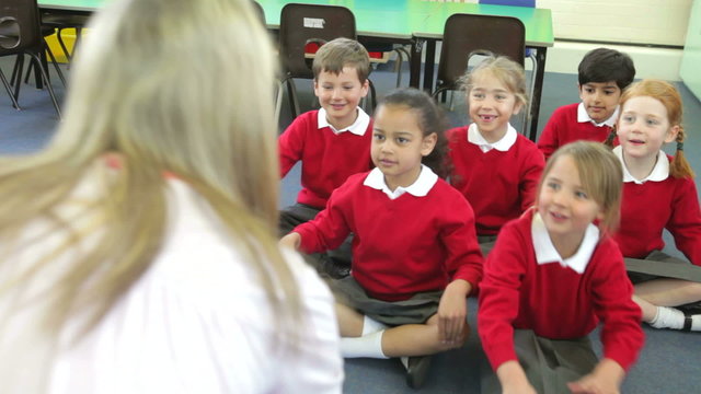 Pupils Copying Teacher's Actions Whilst Singing Song