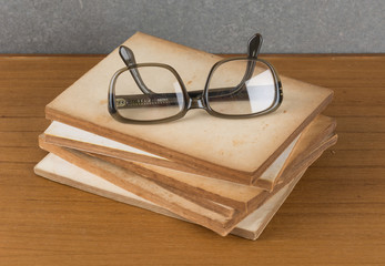 stack of old books with glasses
