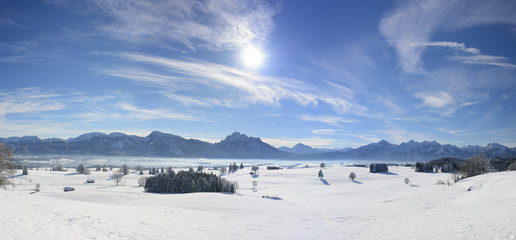 Winter Panorama in Bayern am Forggensee im Allgäu mit Berge der Ammergauer Alpen