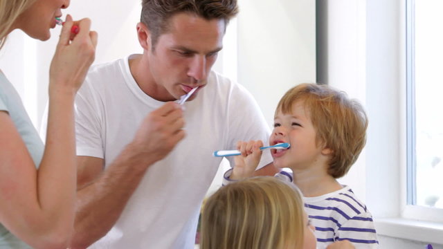 Family Brushing Teeth In Bathroom Together