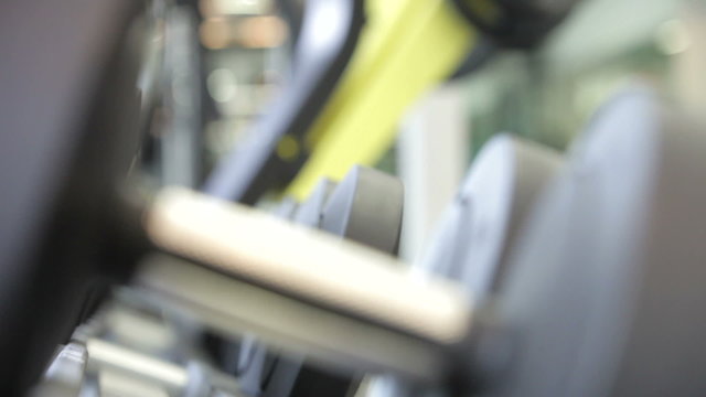 Man Choosing Weights From Rack In Gym