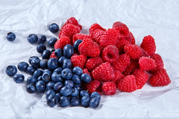 Fresh Organic  Blueberries and Raspberries on crumpled paper.  Rich with vitamins.