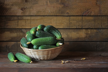 Натюрморт с огурцами. Огурцы в корзине на деревянном столе.