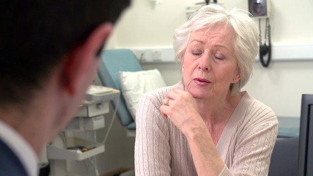 Doctor In Surgery Talking With Worried Senior Female Patient