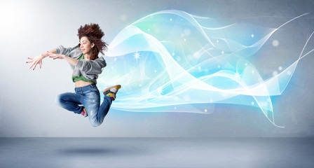 Fototapeta na wymiar Cute teenager jumping with abstract blue scarf around her