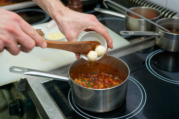 Chef is adding butter to risotto