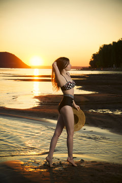 Beautiful woman in bikini on sunset background