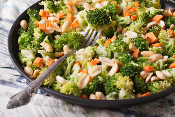 Healthy salad with broccoli, carrots and peanuts close-up horizontal
