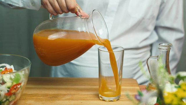 Man pours juice in a glass