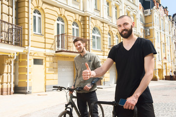 Fototapeta na wymiar Handsome young hipster guys are riding bicycles 