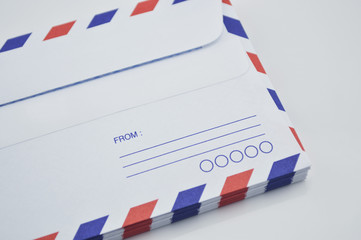 Obraz premium Stack of air mail envelopes on white background