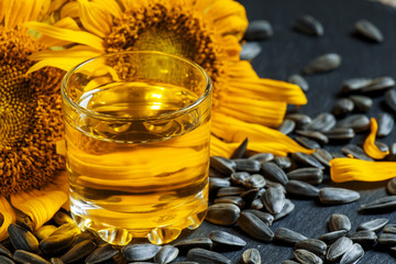 Fresh sunflower oil in a glass with flowers sunflowers and sunfl