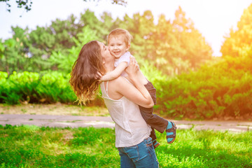 Cute cheerful child with mother play outdoors