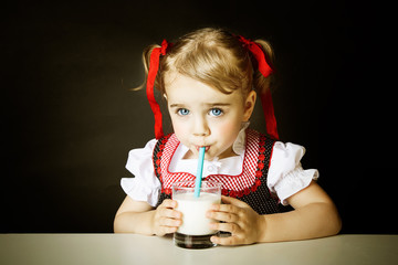 Little girl in bavarian costume drinking milk - 86867664