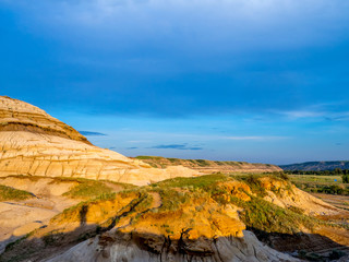 Badlands bathed in the warm light of a summer sunset near drumheller in Alberta Canada.