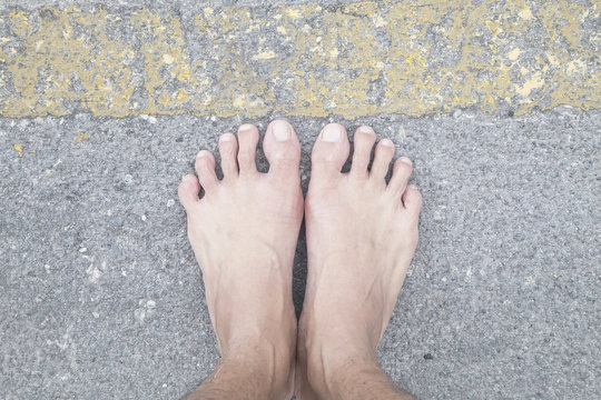 foot female on the asphalt road behind yellow line.  concept, da