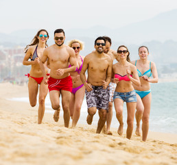 Happy people running at beach