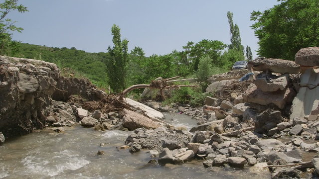 Destroyed concrete bridge over a mountain river by a flood after heavy rain