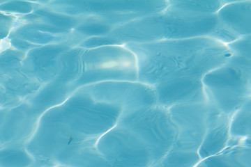 Blue pool water with sun reflections
