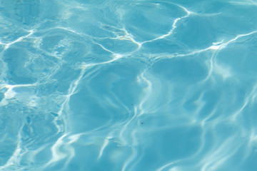 Blue pool water with sun reflections