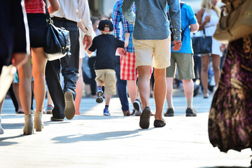 Diversified crowd on sunset sidewalk