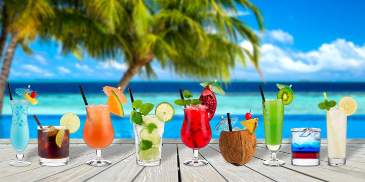 colorful cocktails in front of infinity with pool coco palms and the blue turquoise ocean