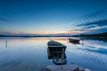 Beautiful lake sunset with fisherman boats