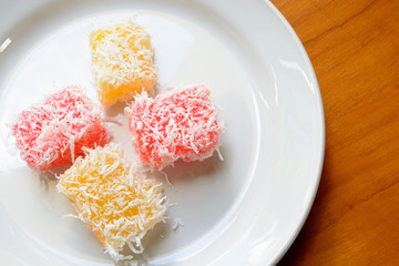 Thai dessert steam-minced cassava with shredded coconut on white dish