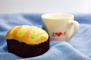 Bun and white coffee mug with word love on side